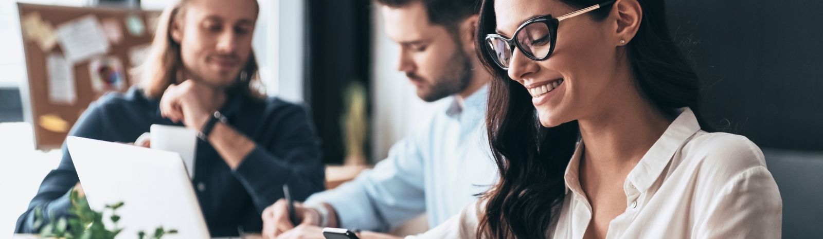 Woman smiling while collaborating with colleagues.